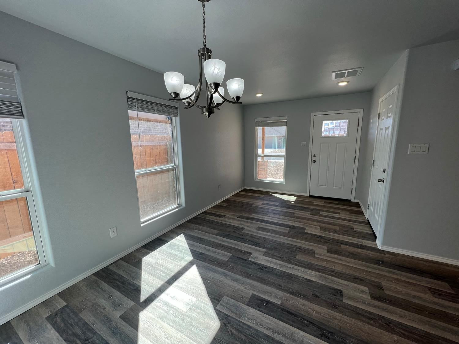 5611 Jarvis Street, Unit B Lubbock, TX 79416 - Photo 18 of 20 a view of an empty room with wooden floor and a window