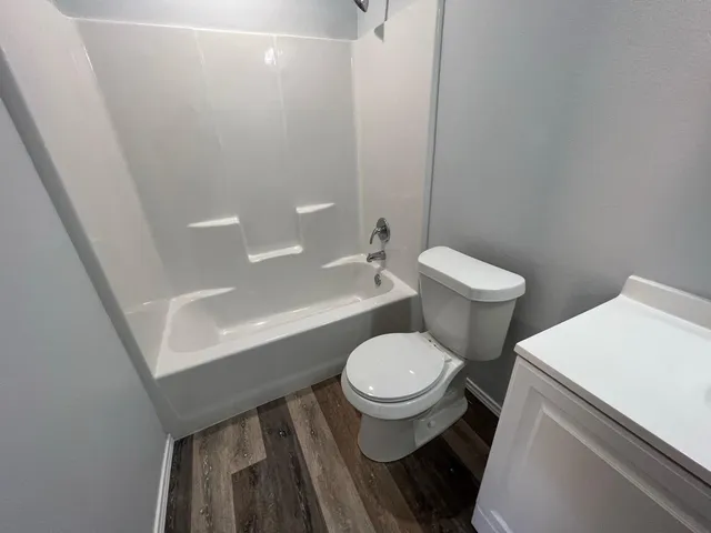 a white toilet sitting next to a bath tub