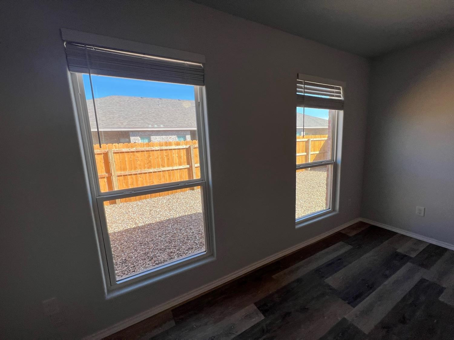 5611 Jarvis Street, Unit B Lubbock, TX 79416 - Photo 5 of 20 a view of an empty room with wooden floor and a window