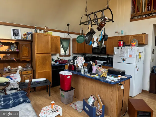 a kitchen with stainless steel appliances granite countertop a refrigerator and a dining table