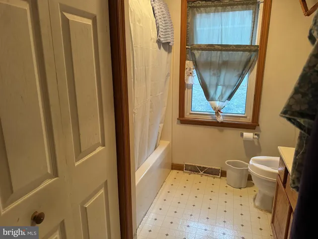 a bathroom with a toilet and a shower curtain