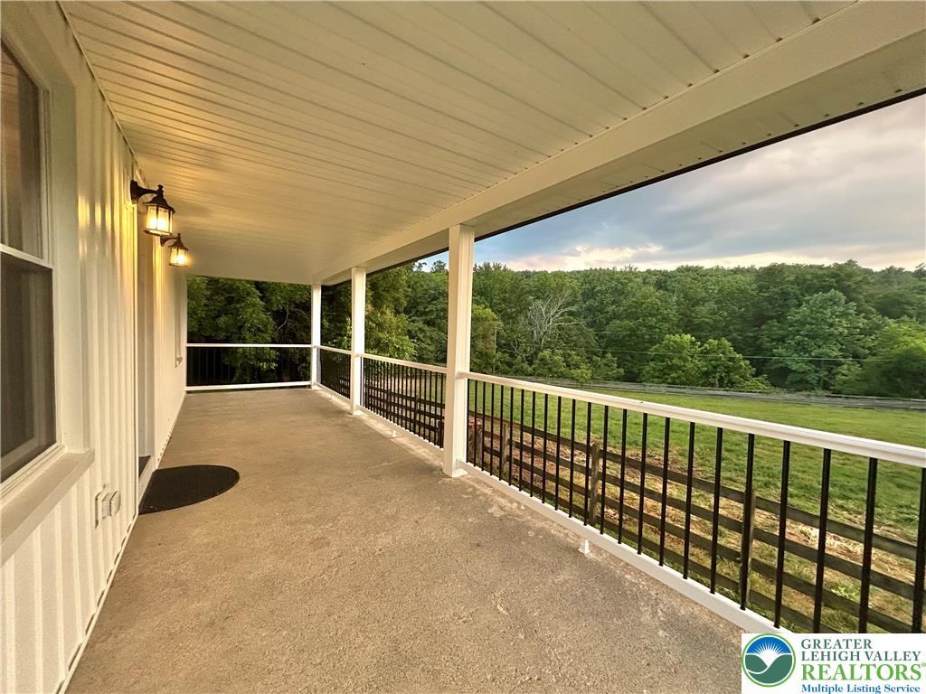 72 Allegheny Road Mount Bethel, PA 18343 - Photo 43 of 72 A spacious covered porch overlooks verdant natural scenery, ideal for peaceful enjoyment.