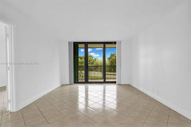 a view of an empty room with glass door and a window