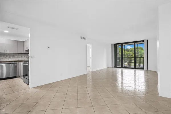 a view of an empty room with a kitchen
