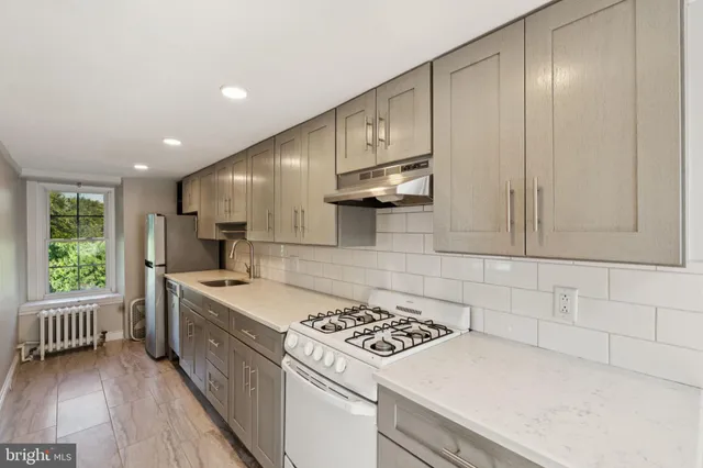 a kitchen that has a sink a stove and window