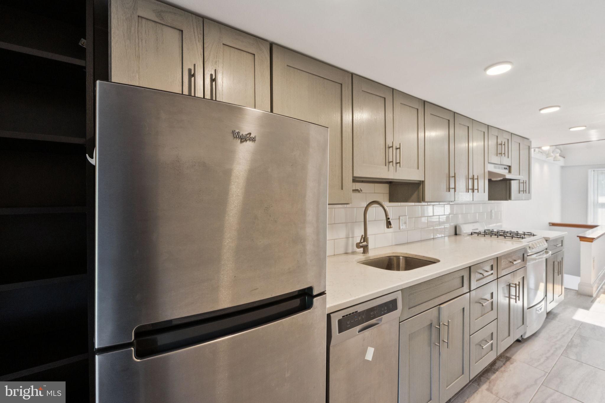 3715 Calumet Street, Unit 3 Philadelphia, PA 19129 - Photo 12 of 19 a kitchen with stainless steel appliances granite countertop a sink refrigerator and cabinets
