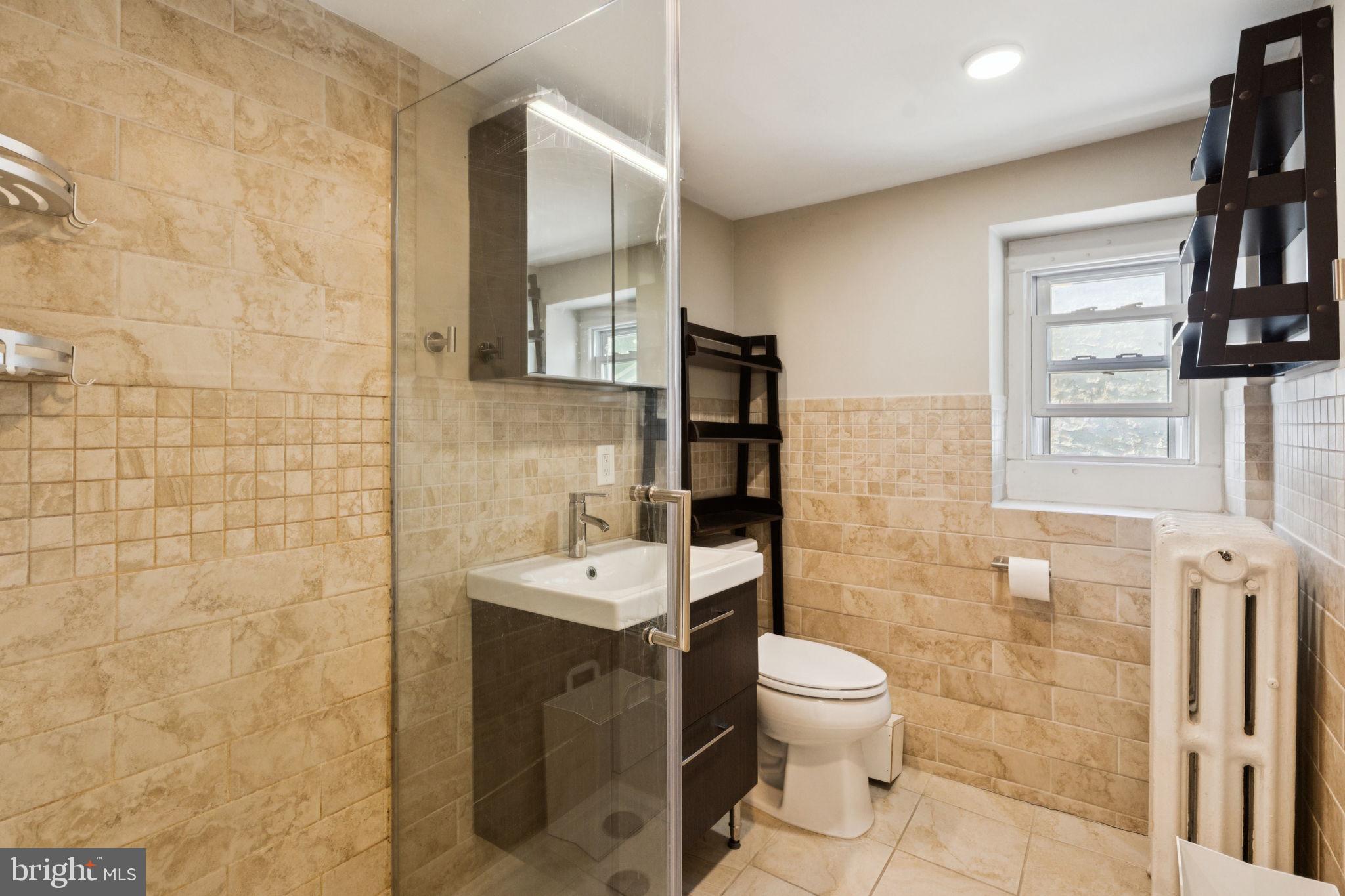 3715 Calumet Street, Unit 3 Philadelphia, PA 19129 - Photo 9 of 19 a bathroom with a toilet a sink and a mirror