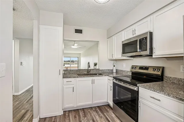 a kitchen with stainless steel appliances granite countertop a sink and stove top oven