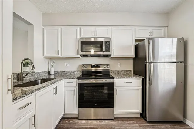 a kitchen with cabinets stainless steel appliances and a sink