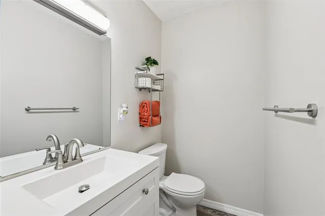 a bathroom with a sink mirror vanity and toilet