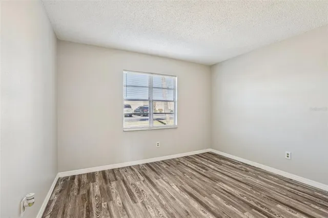 a view of a room with wooden floor and window