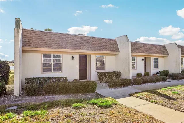a front view of a house with a yard and outdoor seating
