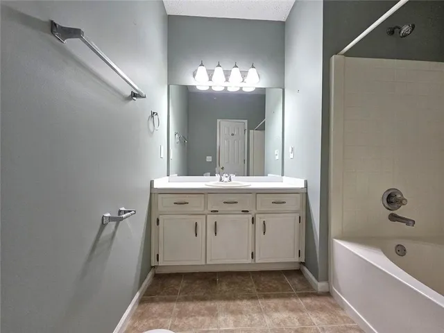 a bathroom with a sink vanity tub and a mirror