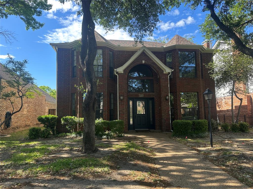 View of front of home with brick siding and a chimney