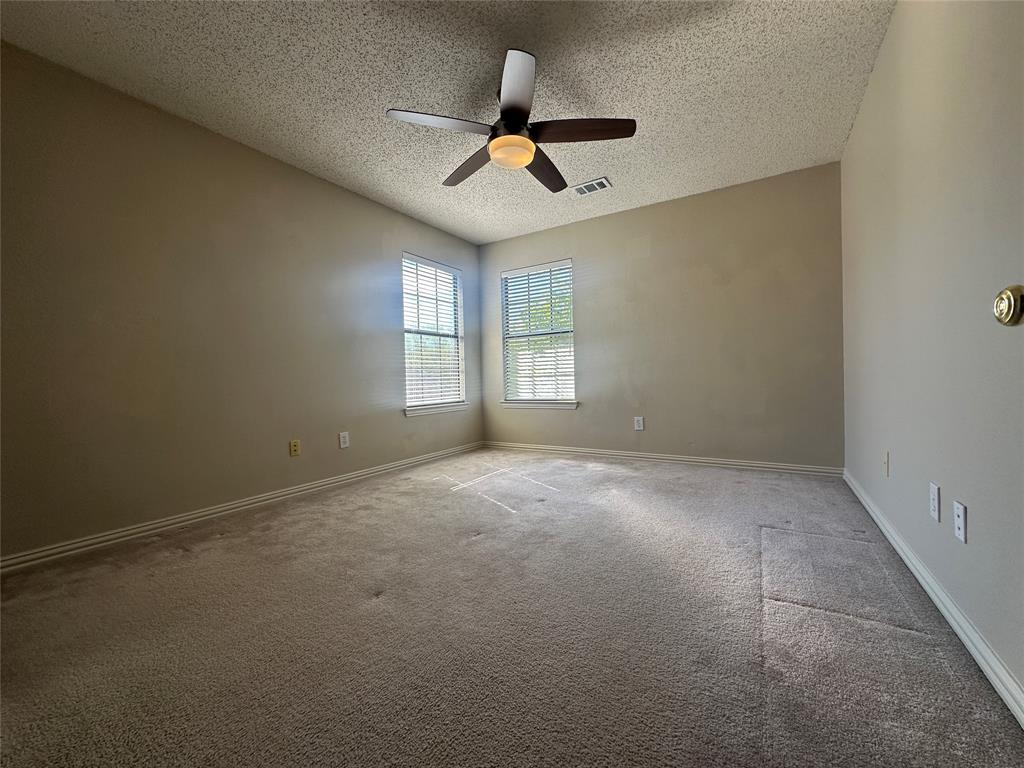 4342 Timberglen Road Dallas, TX 75287 - Photo 20 of 27 Empty room featuring a textured ceiling, light carpet, and a ceiling fan