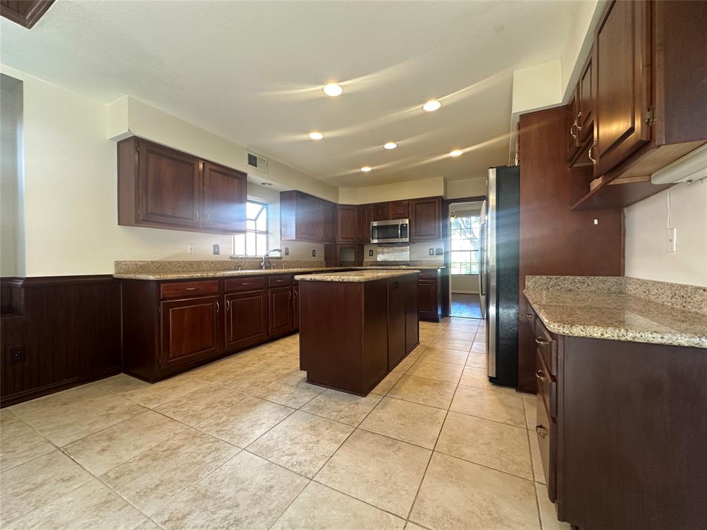 4342 Timberglen Road Dallas, TX 75287 - Photo 9 of 27 Kitchen with a center island, stainless steel appliances, healthy amount of natural light, light tile patterned flooring, and recessed lighting