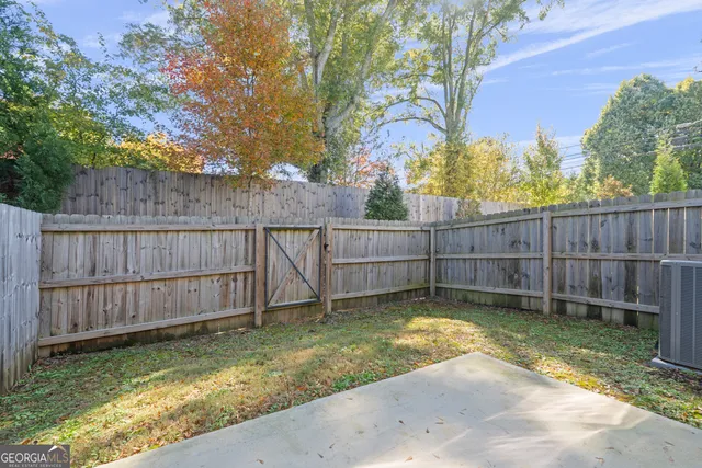 a view of a backyard with a small cabin and wooden fence