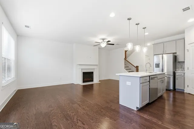 a view of kitchen with sink and refrigerator