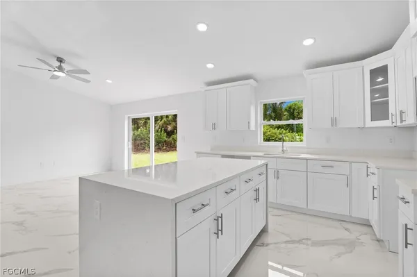 a kitchen with white cabinets and window