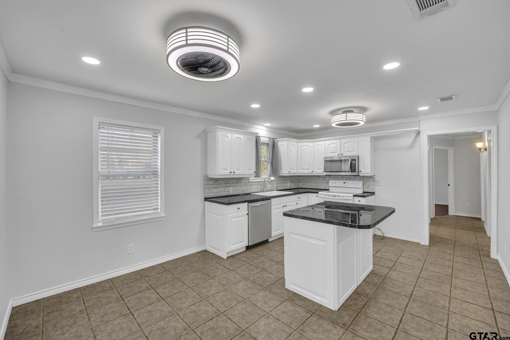 3743 Smelley Road Longview, TX 75605 - Photo 3 of 25 a kitchen with kitchen island stainless steel appliances granite countertop a stove and a sink