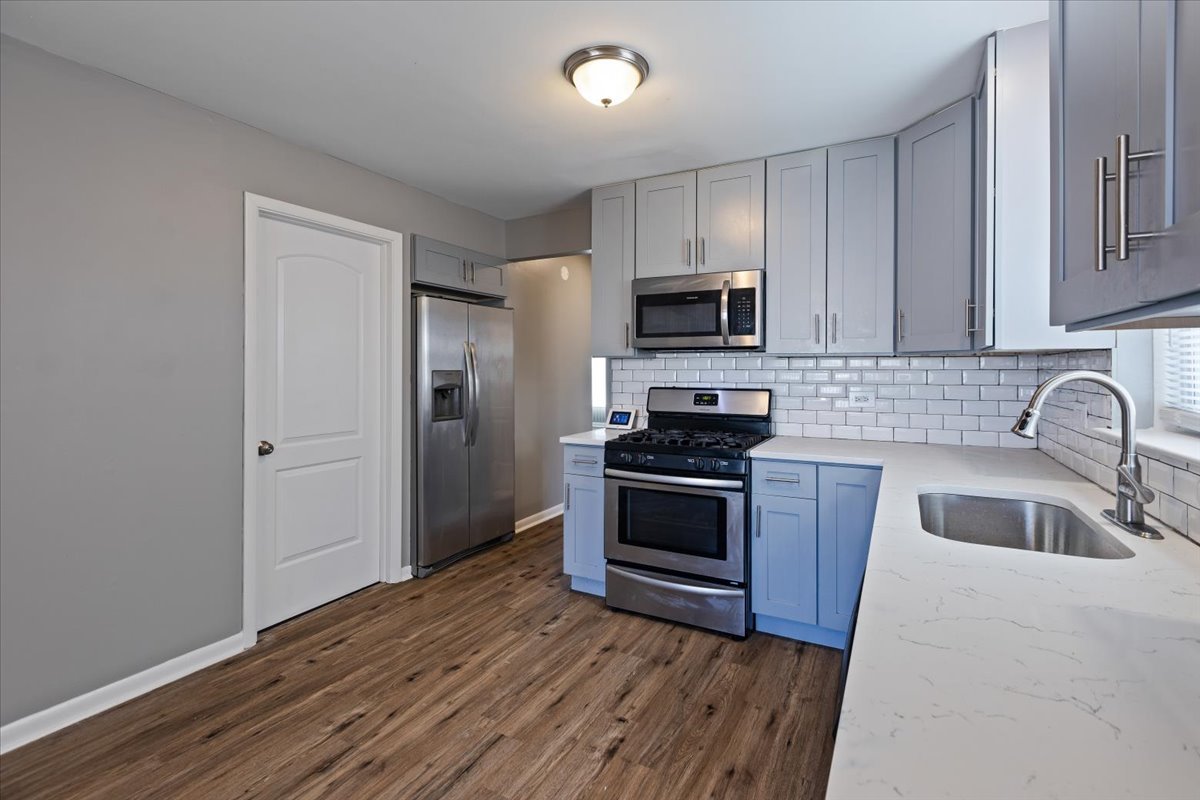 15304 Grant Street Dolton, IL 60419 - Photo 11 of 32 a kitchen with granite countertop a refrigerator stove and sink