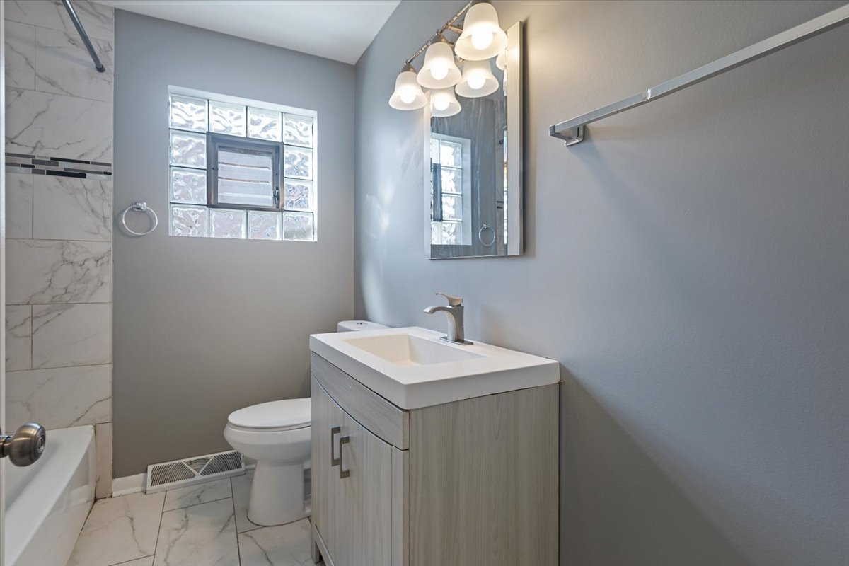 15304 Grant Street Dolton, IL 60419 - Photo 15 of 32 a bathroom with a toilet sink and mirror