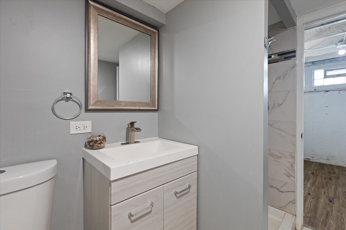 15304 Grant Street Dolton, IL 60419 - Photo 27 of 32 a bathroom with a toilet sink and mirror