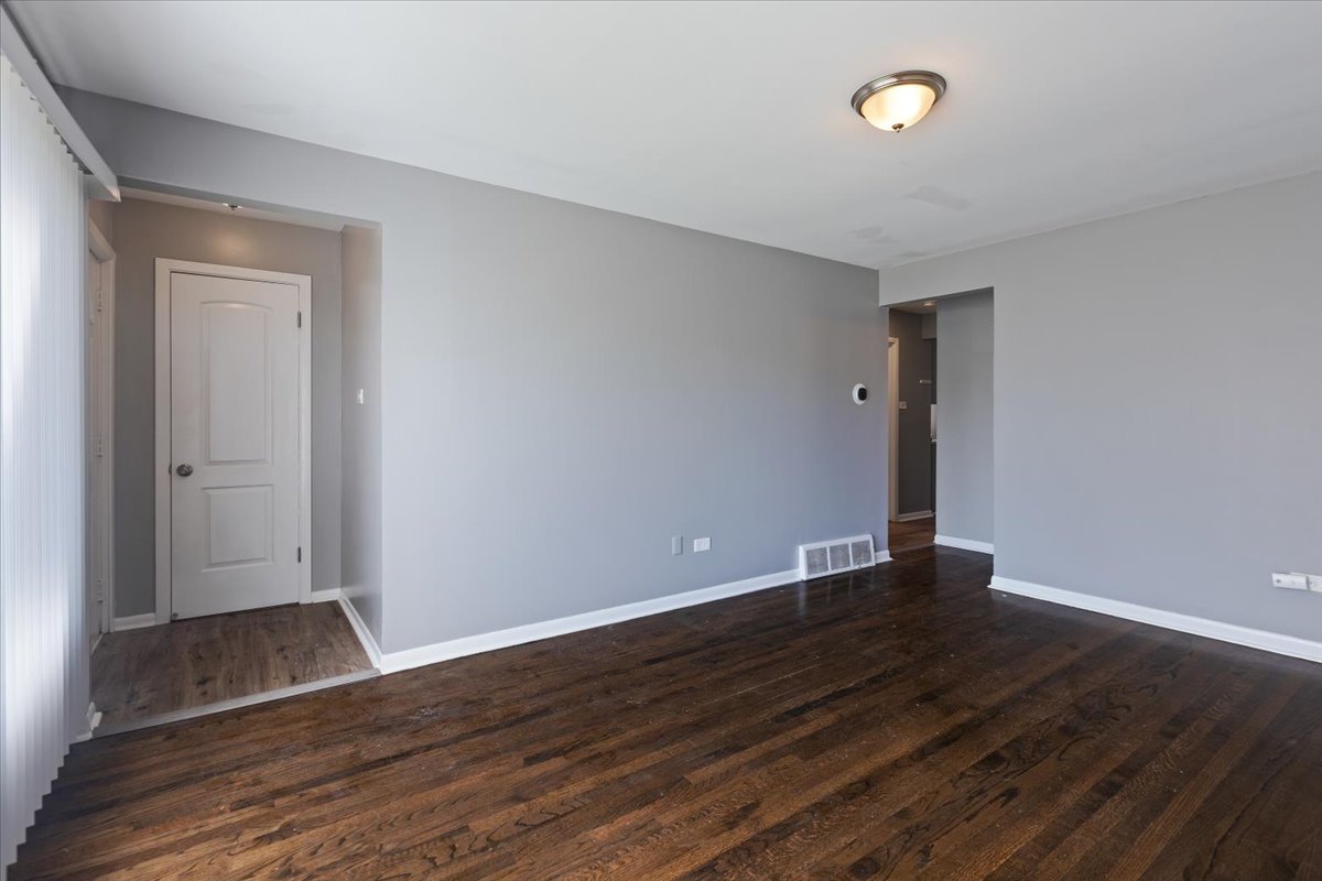 15304 Grant Street Dolton, IL 60419 - Photo 7 of 32 a view of an empty room with wooden floor and a window