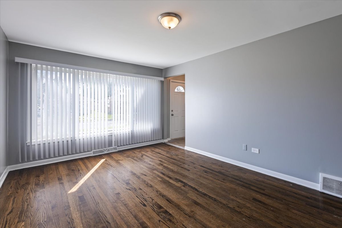 15304 Grant Street Dolton, IL 60419 - Photo 8 of 32 a view of an empty room with wooden floor and a window