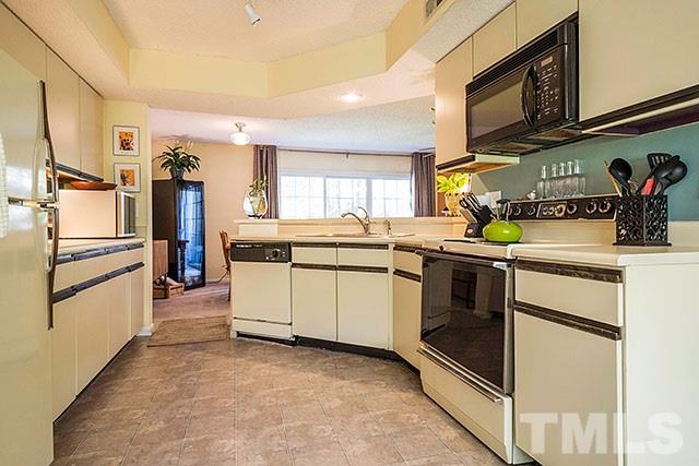 7777 Falcon Rest Circle Raleigh, NC 27615 - Photo 11 of 24 a kitchen with stainless steel appliances and white cabinets