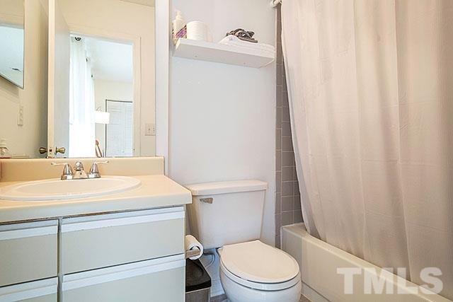 7777 Falcon Rest Circle Raleigh, NC 27615 - Photo 16 of 24 a bathroom with a sink a toilet a mirror and shower curtain