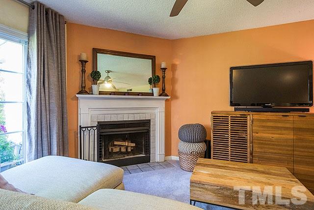 7777 Falcon Rest Circle Raleigh, NC 27615 - Photo 7 of 24 a living room with furniture a flat screen tv and a fireplace