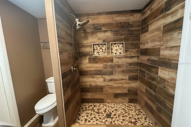 a bathroom with a toilet and a shower