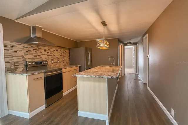 a kitchen with stainless steel appliances granite countertop a stove and a refrigerator