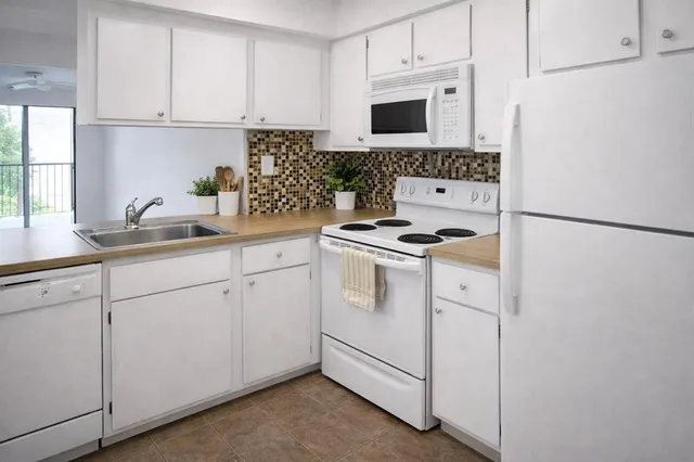 a kitchen with white cabinets sink and white appliances