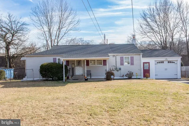 a view of a house with a yard and large tree