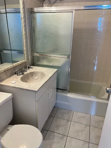 a bathroom with a sink mirror vanity and toilet
