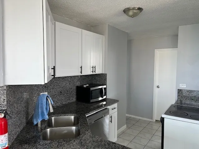 a kitchen with granite countertop a stove and a sink