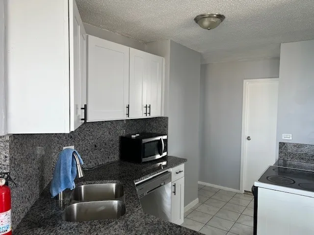 a kitchen with granite countertop a stove and a sink