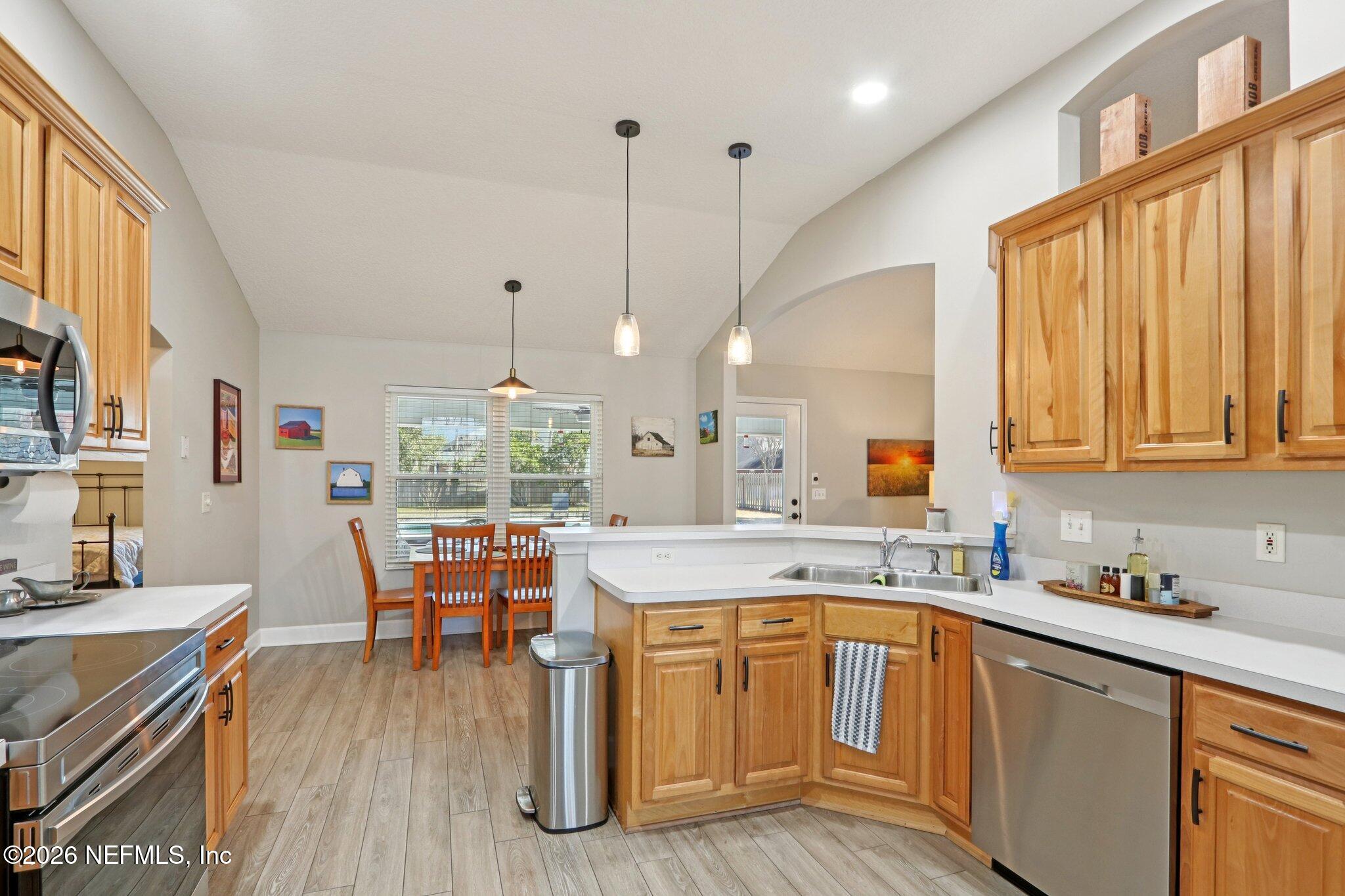 1405 Sinclair Lane Jacksonville, FL 32221 - Photo 17 of 37 a kitchen with a stove a sink a dining table and chairs