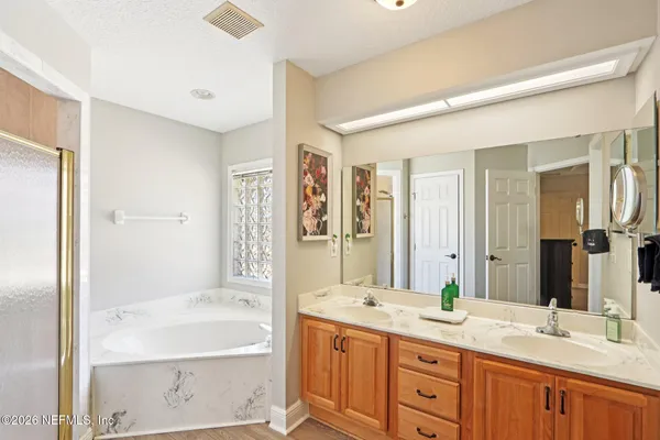 a bathroom with a granite countertop sink mirror bathtub and double