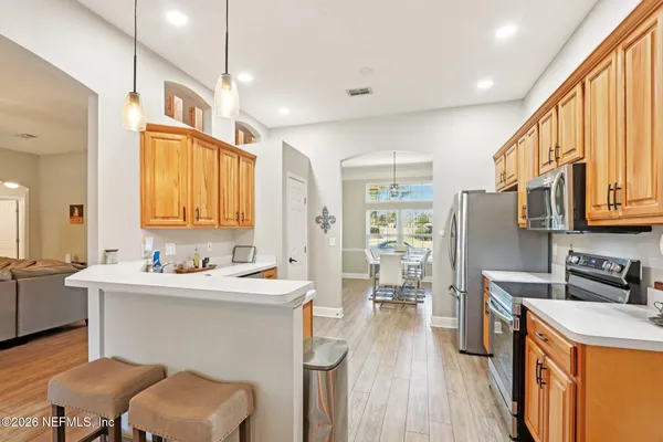 a kitchen with stainless steel appliances sink stove and wooden cabinets