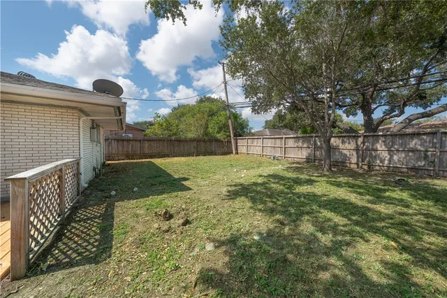 a view of backyard with wooden fence