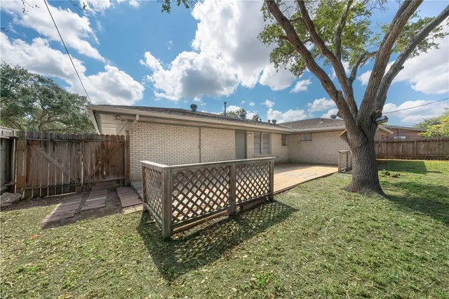 a view of a yard with wooden fence and a large tree