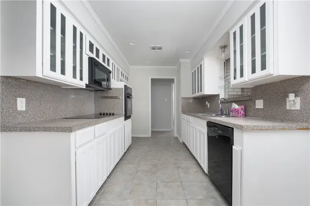 a kitchen with stainless steel appliances granite countertop a lot of cabinets