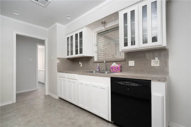 a kitchen with granite countertop a sink dishwasher stove and cabinets