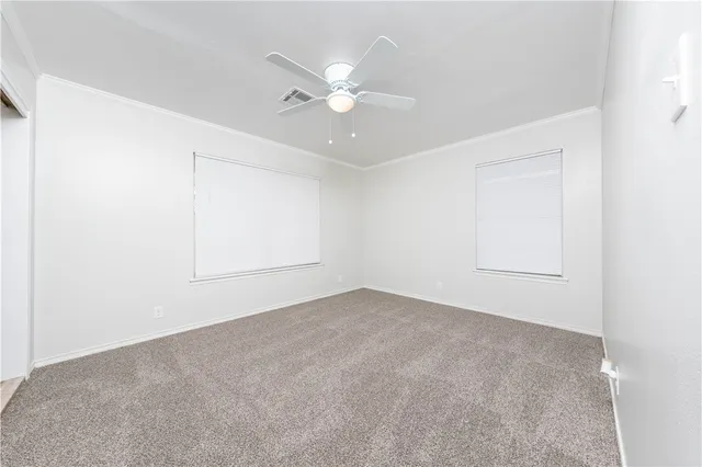an empty room with a window and ceiling fan