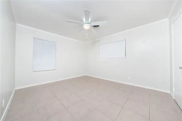 an empty room with a ceiling fan and a window