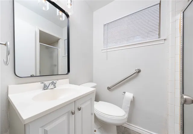 a bathroom with a sink toilet and mirror