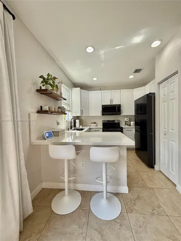 a kitchen with stainless steel appliances granite countertop a sink and a refrigerator